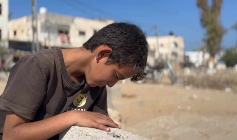 Jongen slaapt op het graf van zijn moeder in Gaza